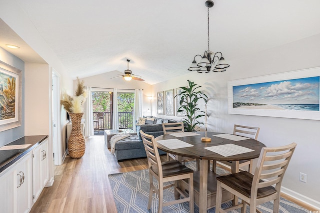 dining room with light wood-style floors, lofted ceiling, a ceiling fan, a chandelier, and baseboards