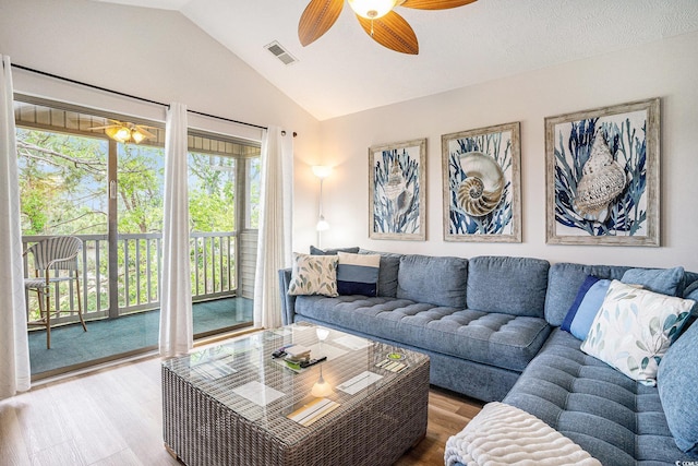 living area with wood finished floors, lofted ceiling, and a ceiling fan