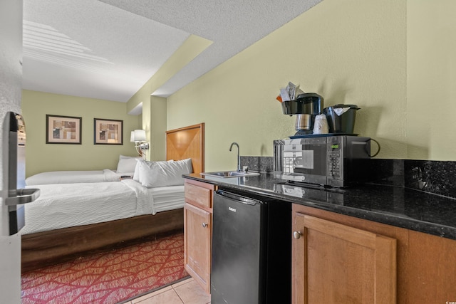 504 N Ocean Blvd N Unit 309, Myrtle Beach, SC 29577 - kitchen featuring a sink, stainless steel microwave, open floor plan, light tile patterned floors, and brown cabinets
