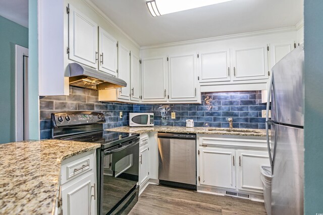 2805 N Ocean Blvd Unit 113, Myrtle Beach, SC 29577 - kitchen featuring stainless steel appliances, under cabinet range hood, a sink, white cabinets, and wood finished floors