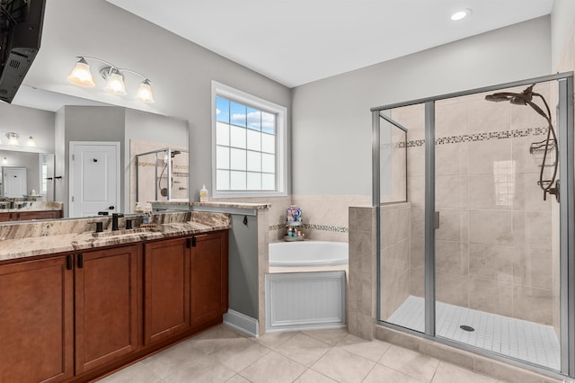 bathroom with a shower stall, tile patterned flooring, a garden tub, and vanity