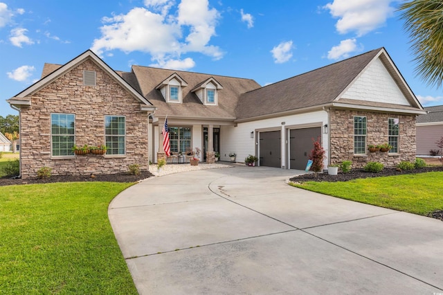 view of front of home with stone siding, a garage, a front yard, and driveway