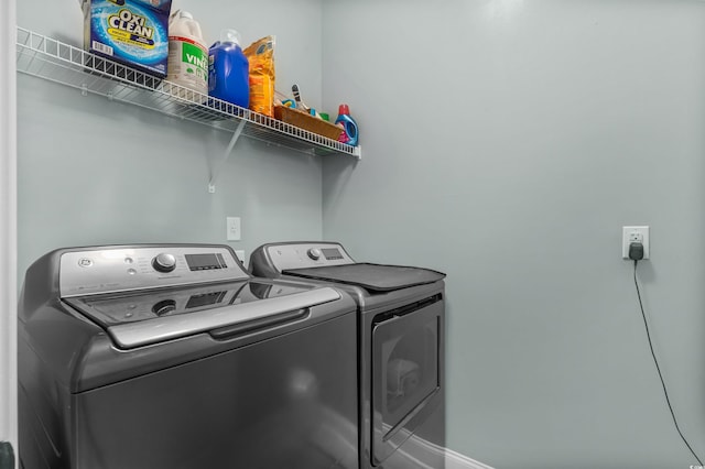laundry room with washer and clothes dryer and baseboards