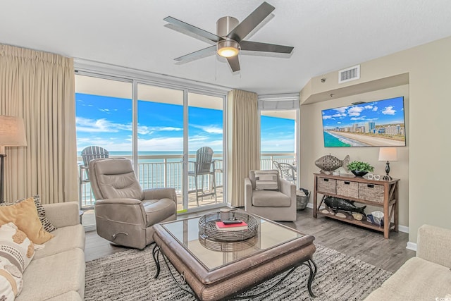 living area featuring wood finished floors, ceiling fan, and healthy amount of natural light