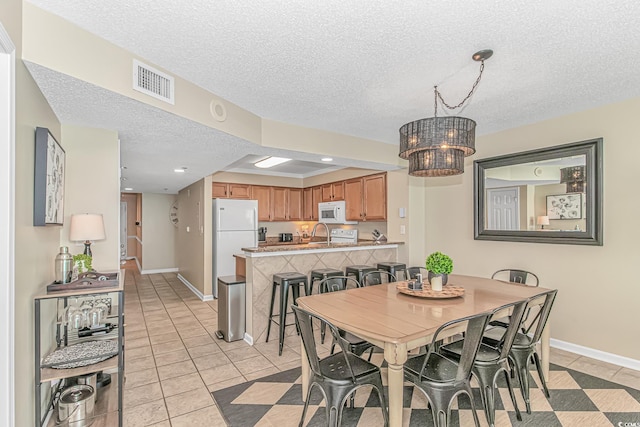 dining space featuring a textured ceiling, a chandelier, light tile patterned flooring, baseboards, and recessed lighting