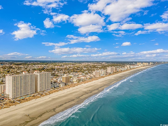 drone / aerial view featuring a city view, a water view, and a view of the beach