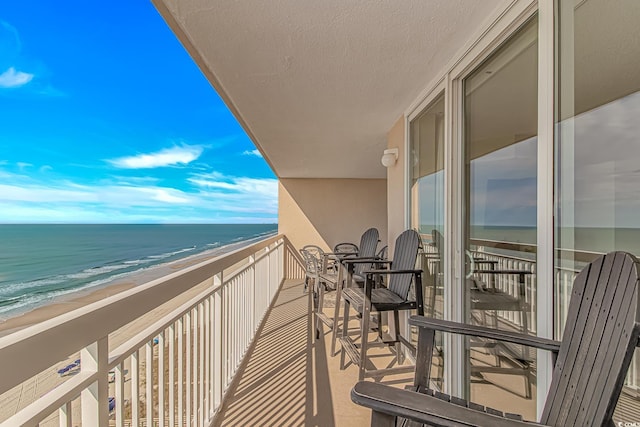 balcony with view of water and beach