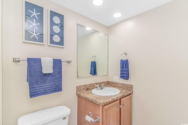 half bathroom with toilet and vanity