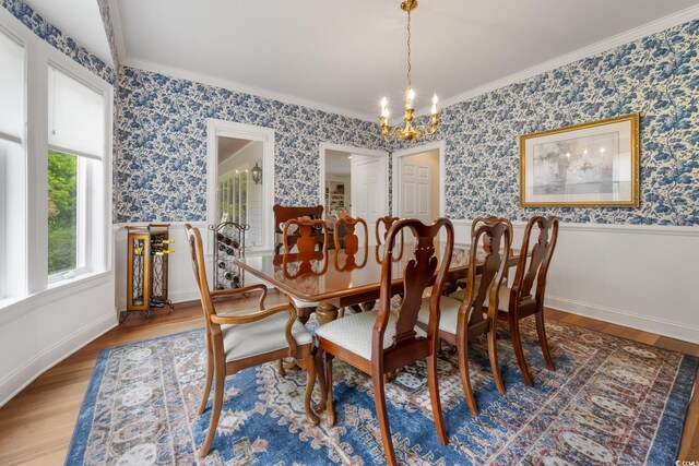 352 Old Carriage Loop, Georgetown, SC 29440 - dining room featuring a chandelier, wainscoting, wood finished floors, ornamental molding, and wallpapered walls
