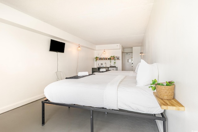 bedroom featuring baseboards and concrete floors