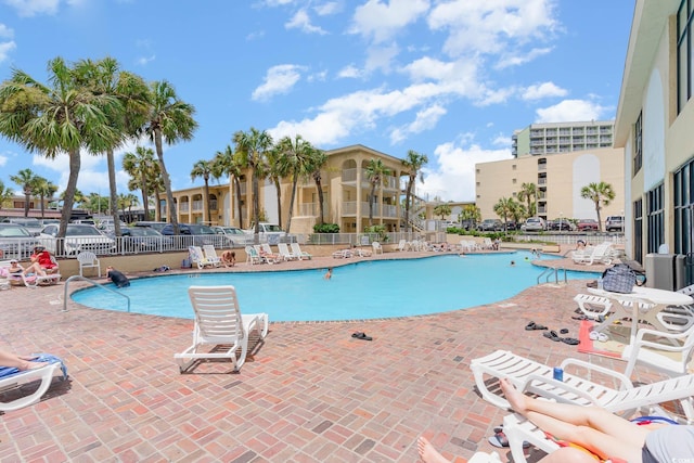 community pool featuring fence and a patio