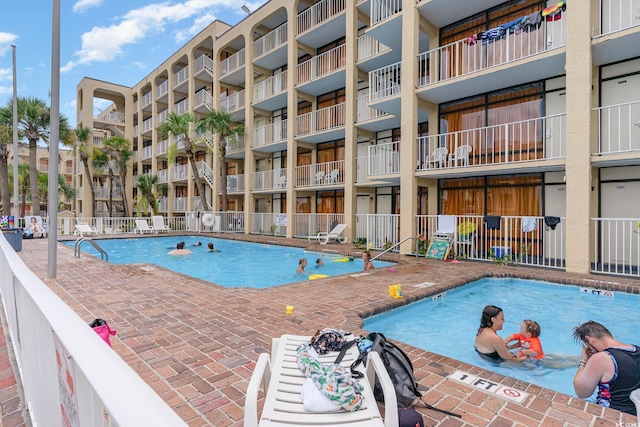 community pool with fence and a patio