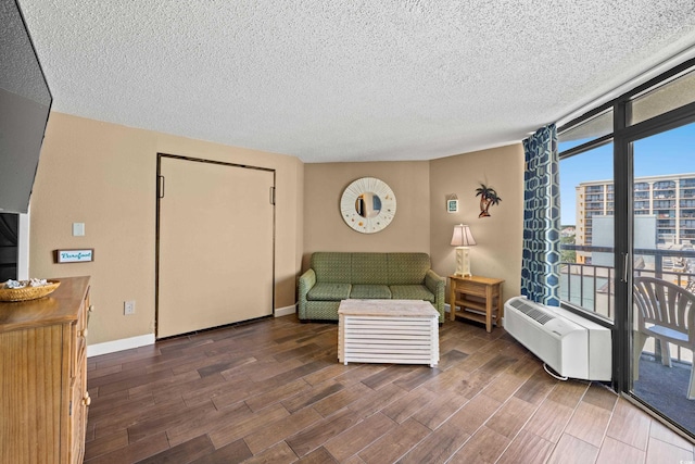 living room featuring wood finished floors, a textured ceiling, and a wall of windows