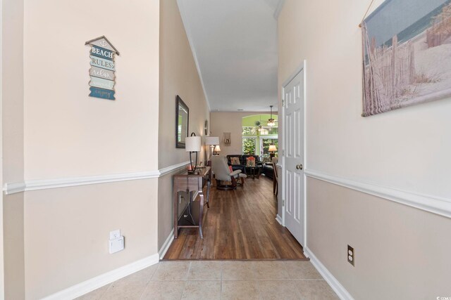 corridor featuring tile patterned flooring and baseboards
