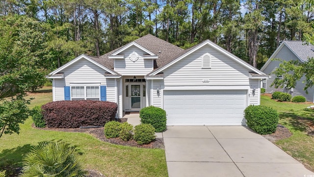 traditional-style house with an attached garage, concrete driveway, a front yard, and roof with shingles