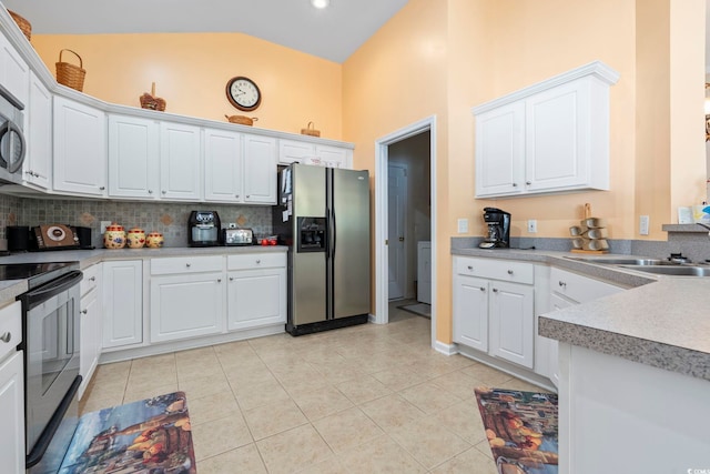 kitchen featuring appliances with stainless steel finishes, decorative backsplash, light tile patterned floors, white cabinets, and high vaulted ceiling
