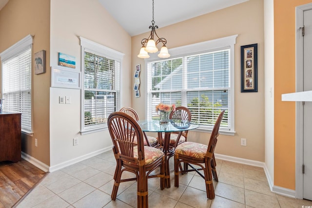 dining area with plenty of natural light, baseboards, lofted ceiling, and a chandelier