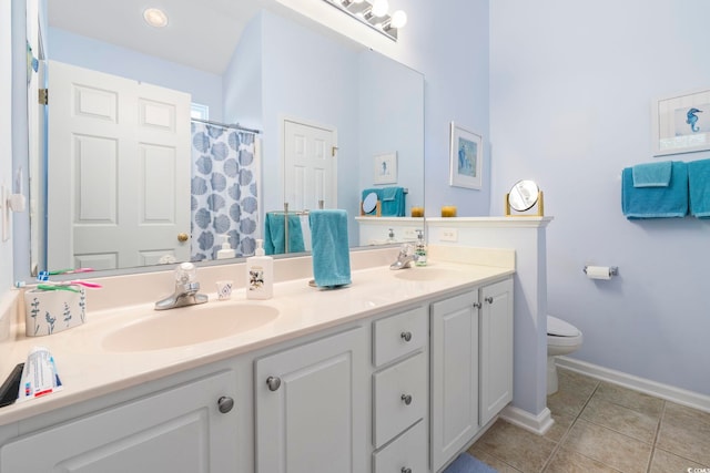 bathroom with tile patterned flooring, toilet, double vanity, and baseboards
