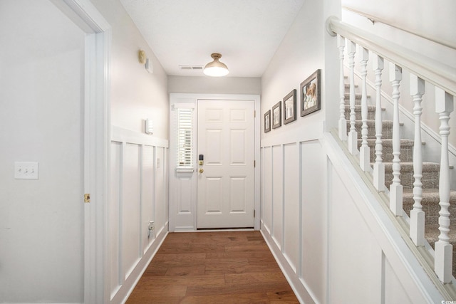 1379 Cottage Dr, Myrtle Beach, SC 29577 - entryway featuring dark wood-style flooring, stairs, a decorative wall, and wainscoting
