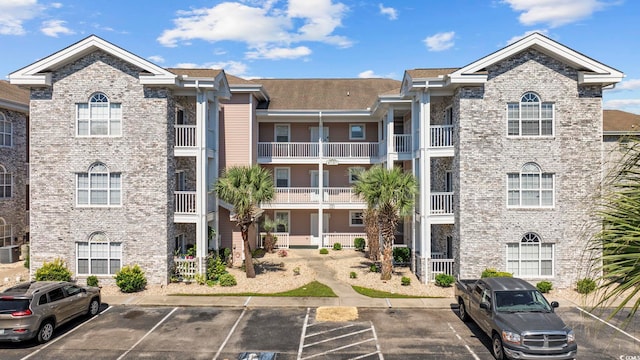 view of property featuring uncovered parking and central air condition unit