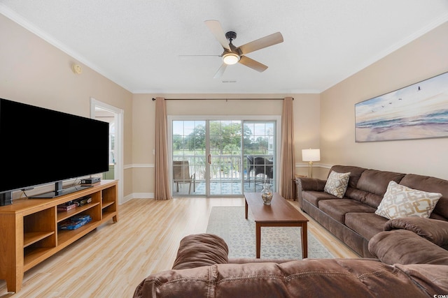 living room with a ceiling fan, light wood-style flooring, ornamental molding, and baseboards