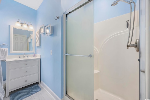 bathroom featuring a shower stall, vanity, and baseboards
