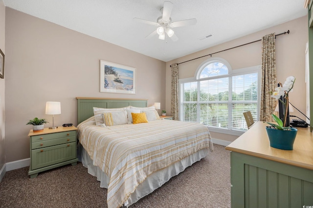 bedroom with dark carpet, baseboards, and a ceiling fan