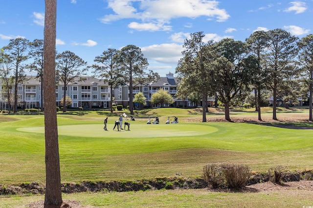 view of home's community featuring golf course view and a yard