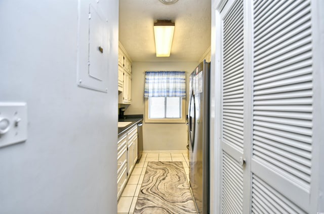 9621 Shore Dr Unit F-117, Myrtle Beach, SC 29572 - kitchen with stainless steel appliances, electric panel, baseboards, light tile patterned floors, and dark countertops