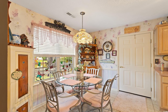 dining area with wallpapered walls and light tile patterned floors