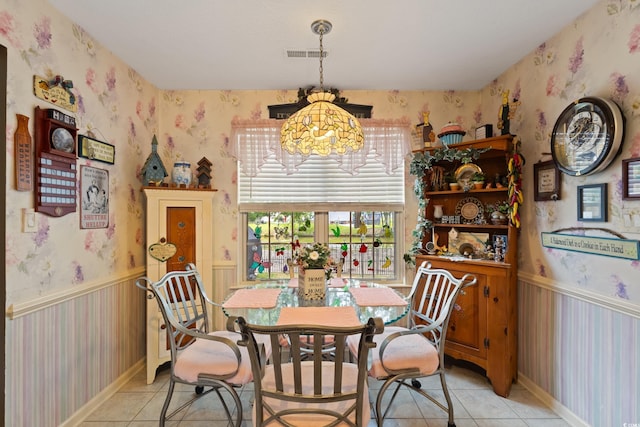 dining space with wallpapered walls, a chandelier, and light tile patterned floors