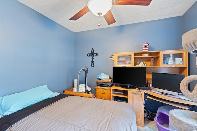 bedroom with an office area, a ceiling fan, and a textured ceiling