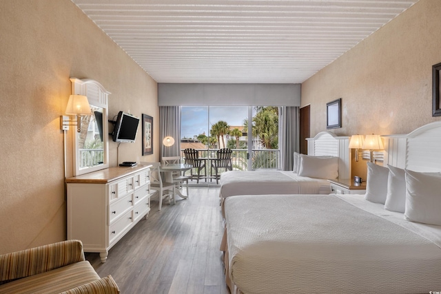 6803 N Ocean Blvd Unit 228, Myrtle Beach, SC 29572 - bedroom featuring a textured wall, access to exterior, and dark wood-type flooring