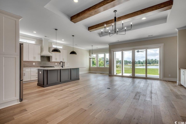 kitchen featuring custom exhaust hood, baseboards, a sink, recessed lighting, and decorative backsplash