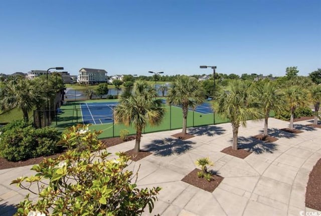 surrounding community with a tennis court and fence