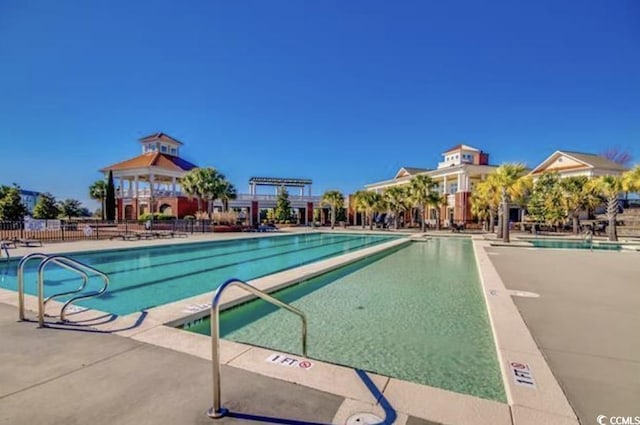 community pool featuring fence and a patio area