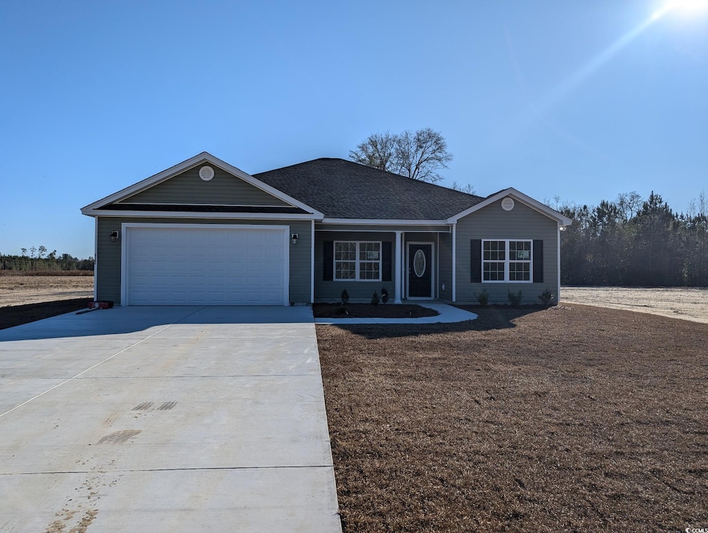 single story home with concrete driveway, an attached garage, and roof with shingles