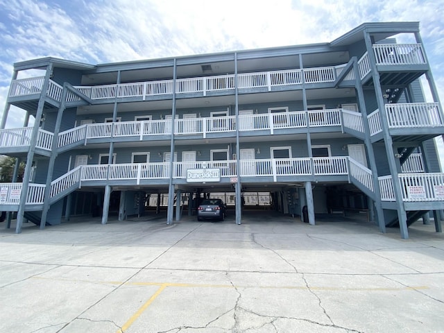 view of apartment building / complex featuring covered parking