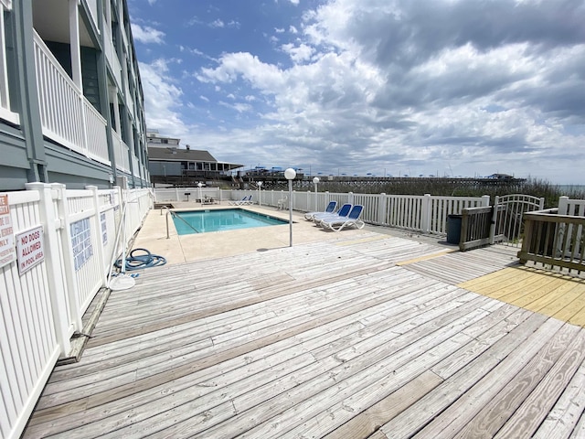 community pool with a deck and fence