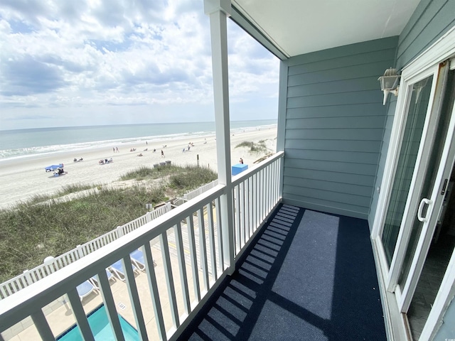 balcony with view of water and beach