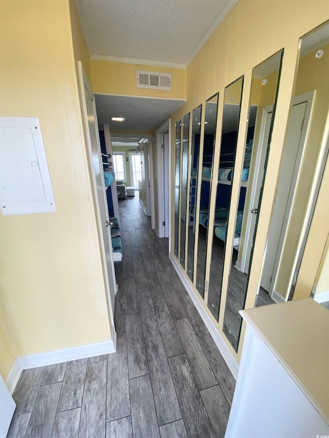 hallway with crown molding, wood finished floors, and electric panel