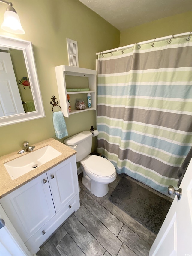 full bathroom with vanity, toilet, and curtained shower