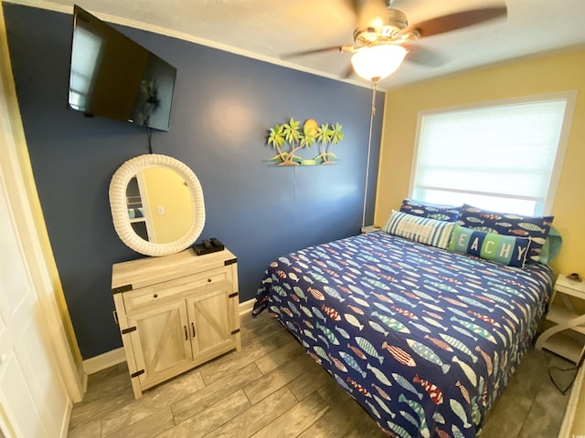bedroom with wood tiled floors, a ceiling fan, and baseboards