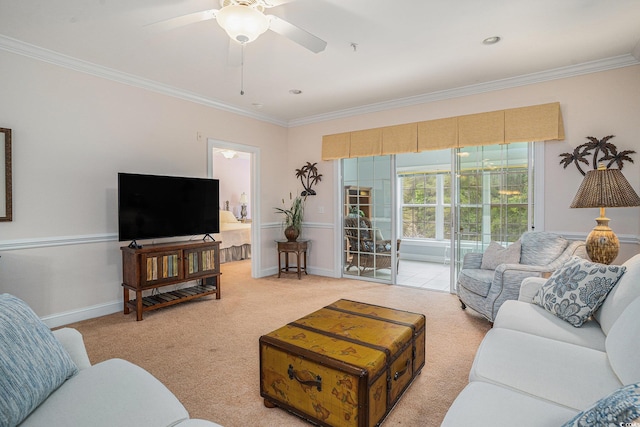 living room with crown molding, light colored carpet, a ceiling fan, and baseboards