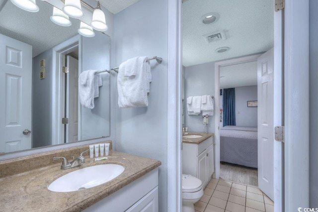 210 75th Ave N Unit 4042, Myrtle Beach, SC 29572 - ensuite bathroom with a textured ceiling, vanity, tile patterned floors, and toilet