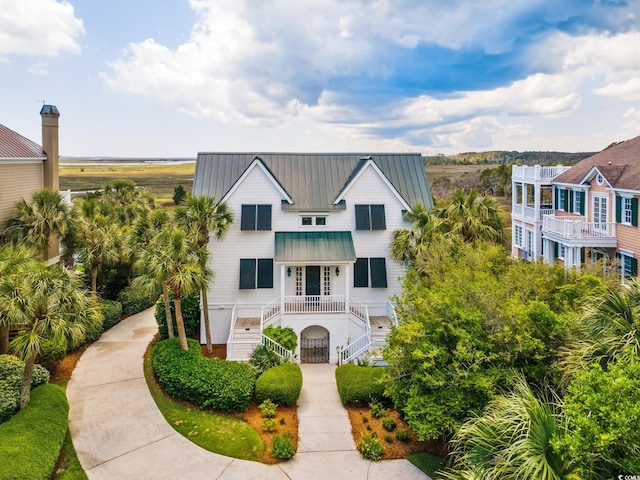 coastal inspired home featuring stairs, a standing seam roof, and metal roof