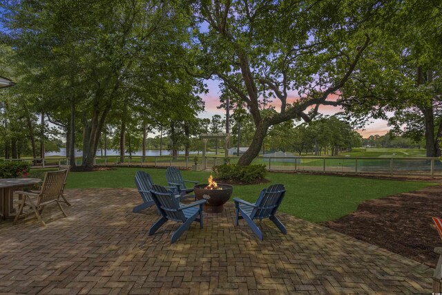 view of patio with a fire pit and a water view