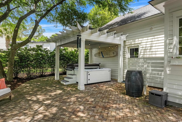 view of patio with a hot tub and a pergola