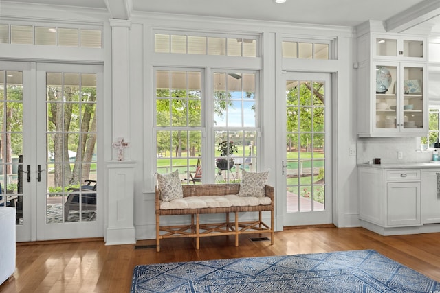 doorway featuring light wood-style flooring, healthy amount of natural light, french doors, and ornamental molding