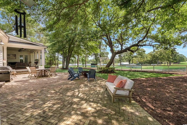 view of patio featuring a ceiling fan, area for grilling, fence, and outdoor dining area